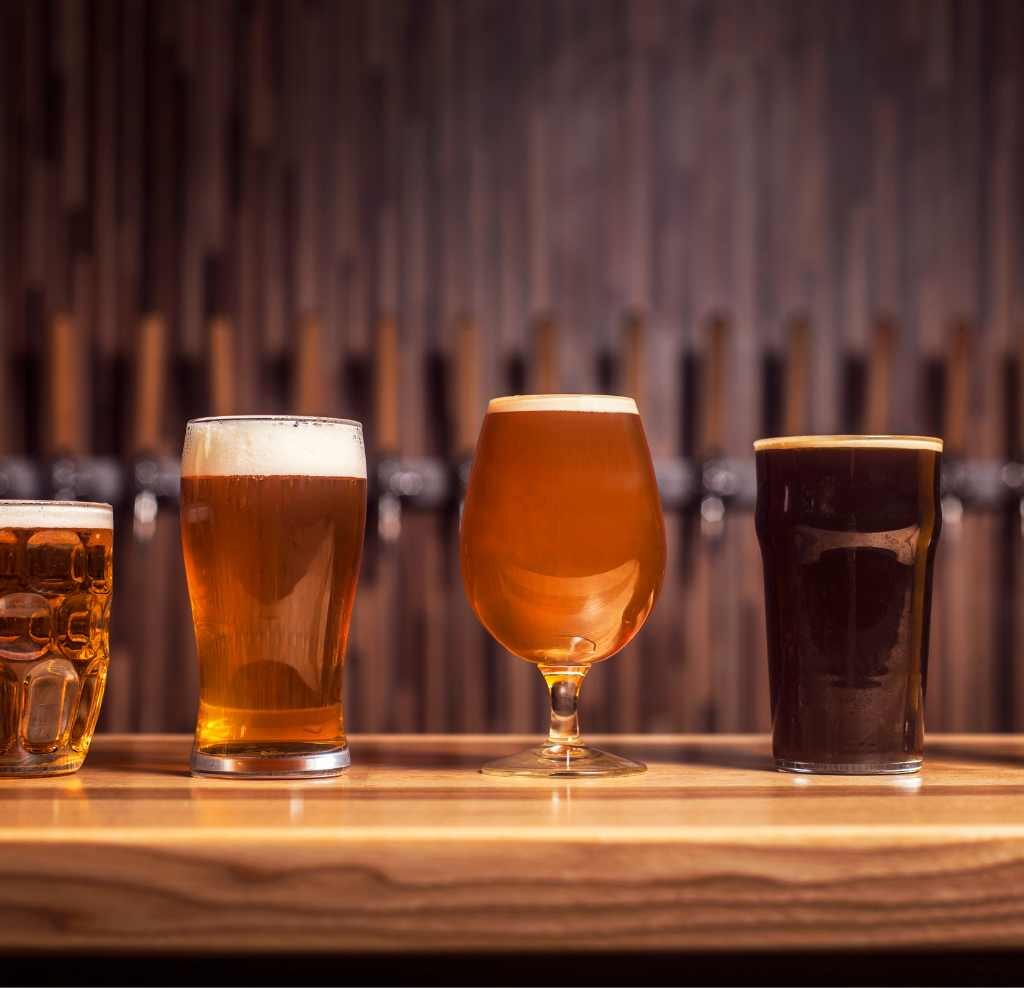 4 beer glasses on a bar