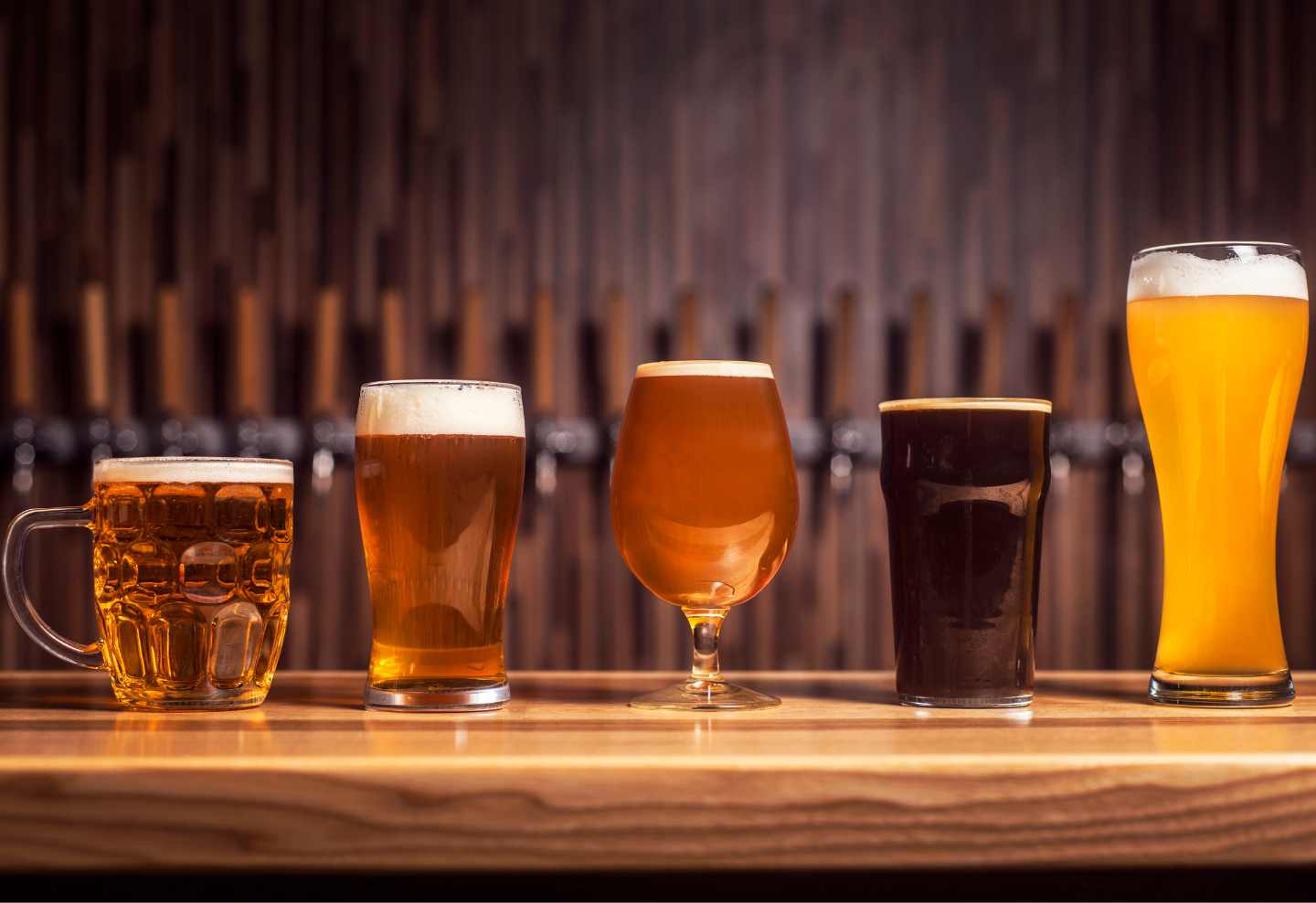 4 beer glasses on a bar