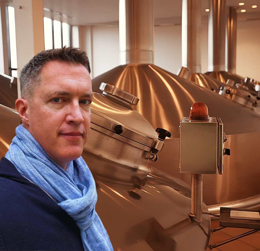 martin dixon visiting a brewery wearing a blue scarf